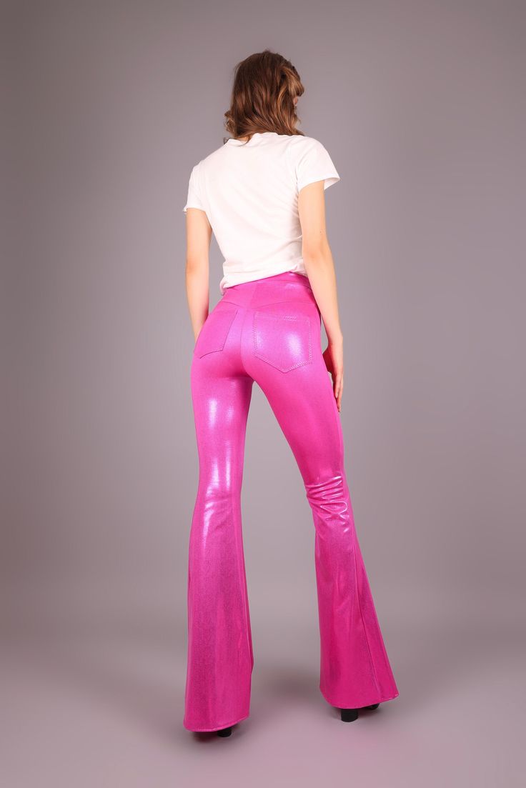 "Dance the night away in these high-waisted leggings in hot pink shiny mystique spandex. The flared legs will catch everyone's attention as you move across the stage. These are V-cut in the back with pockets. The 4 cm wide waistband gives you a comfortable fit. Features: * Tight-fit * Slip-on * High waist * Bell bottom legs * Shiny hot pink mystique spandex, 80% nylon, 20% spandex * V-cut shaped back & pockets * Solid red front * 4 cm wide waistband * 4-way stretch * The model is 179 cm and wearing a size XS x 36\" * Fits true to size. Take your regular size. Available in size XS-XXL. Hip measurement (measures on the actual hip bone:/low waist): XS: 75-80 cm / 29,5\" - 31,5\" S: 81-86 cm / 31,8\" - 33,8\" M: 87-92 cm / 34,2\" - 36,2\" L: 93-98 cm / 36,6\" - 38,6\" XL: 99-105 cm / 39\" - 41 Fitted Pink Bottoms For Night Out, Shiny Fitted Bottoms For Spring, Fitted Shiny Pants For Spring, Glamorous Shiny Fitted Bottoms, Fitted Shiny Wide Leg Bottoms, Fitted Wide Leg Shiny Bottoms, Shiny Fitted Leggings For Parties, Pink Leggings For Night Out In Spring, Shiny Fitted Wide Leg Bottoms