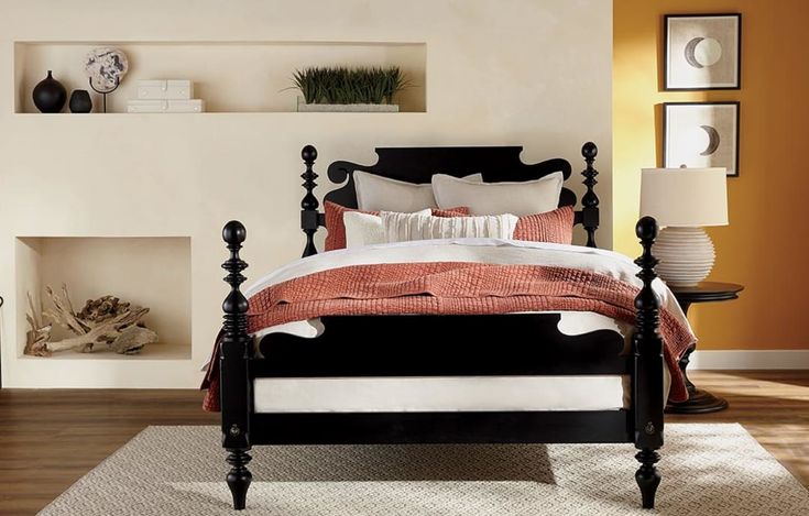 a black and white bed in a room with orange walls