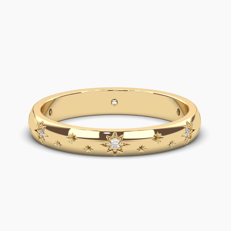 a yellow gold ring with stars and diamonds on the inside, in front of a white background