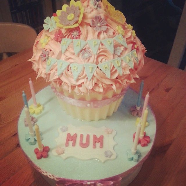 a cupcake decorated with pink icing on top of a table