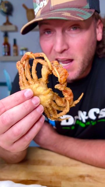 a man holding up a piece of food in front of his face