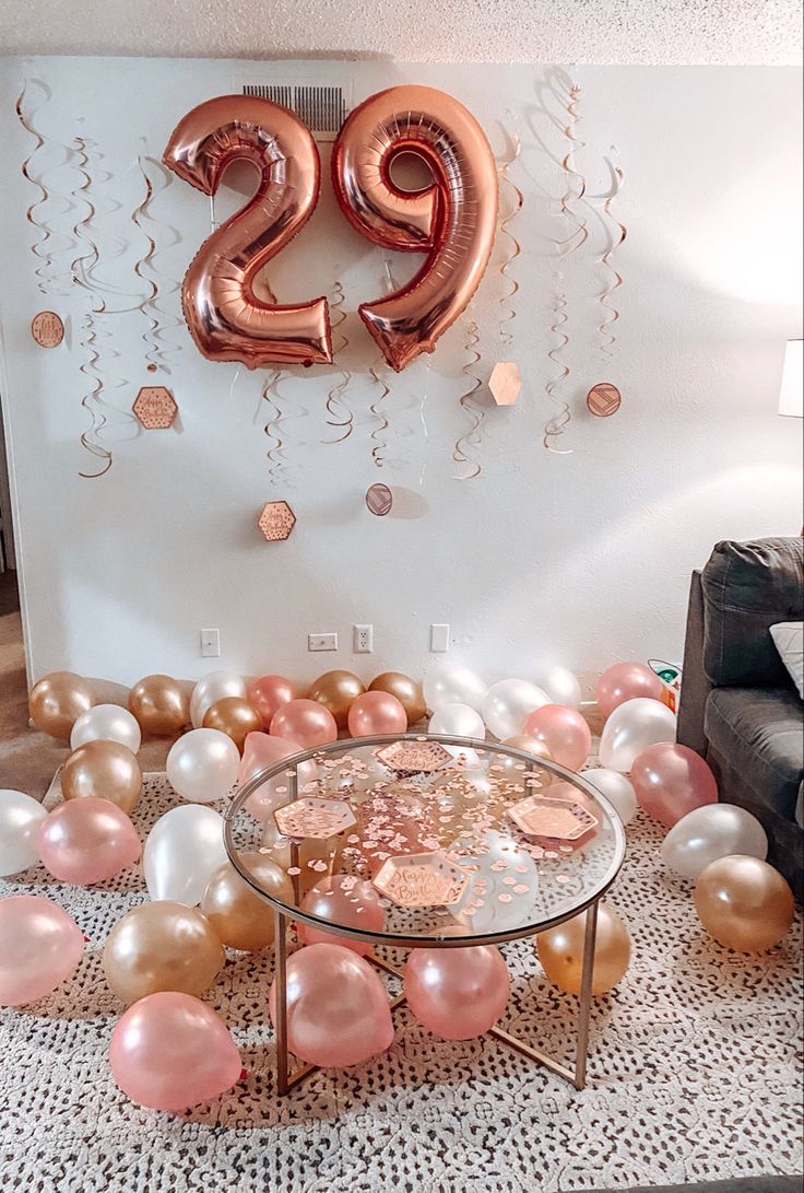 balloons and confetti are on the floor in front of a large number twenty sign