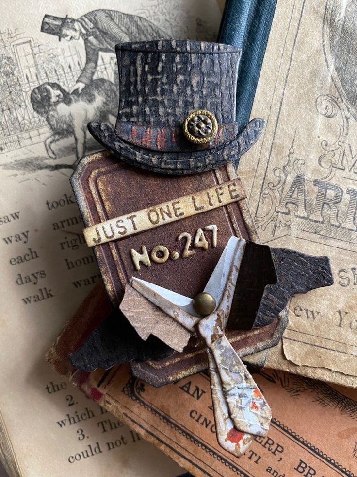 an old book with a top hat on it and some keys attached to the cover