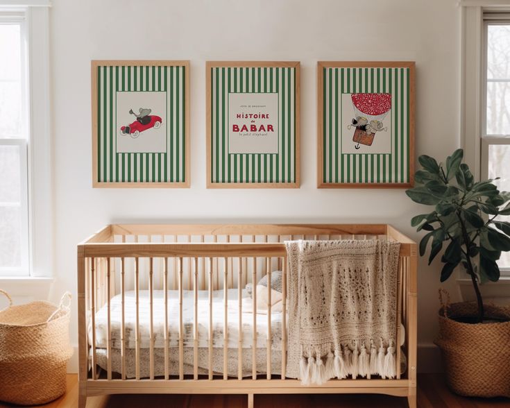 a baby's room with two framed pictures on the wall and a crib