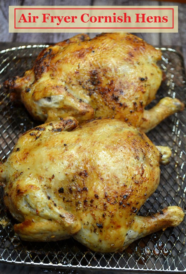 two whole chickens sitting on top of a wire rack with the words air fryer cornish hens