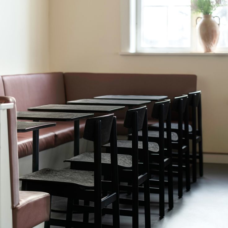 a row of black tables sitting next to each other in front of a brown couch