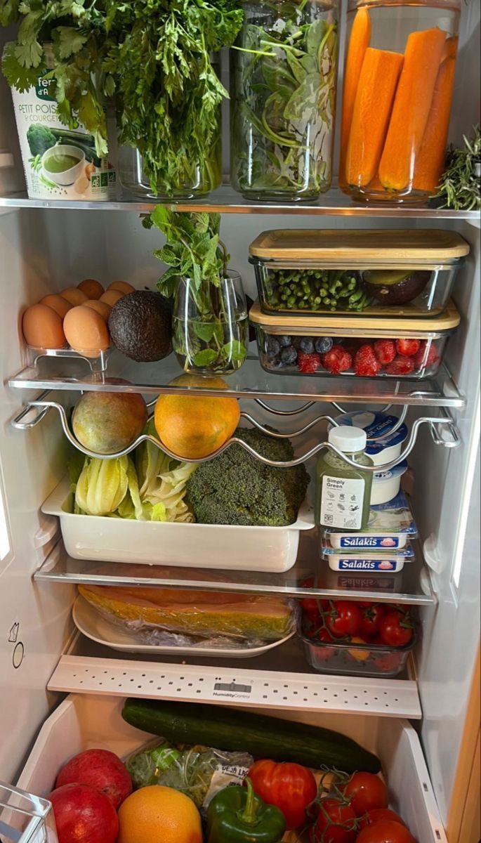 an open refrigerator filled with lots of different types of vegetables and fruits in it's doors