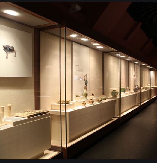 a room filled with lots of vases sitting on top of glass shelves next to each other