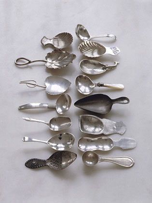 a collection of silver spoons and other kitchen utensils