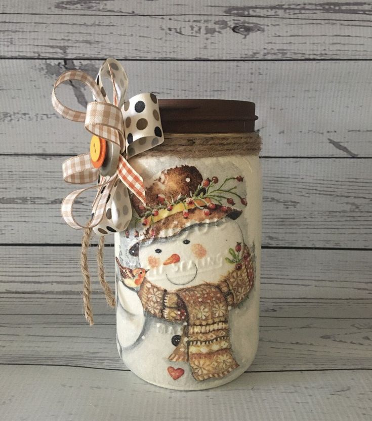 a jar with a christmas decoration on the lid and a bow around it's neck