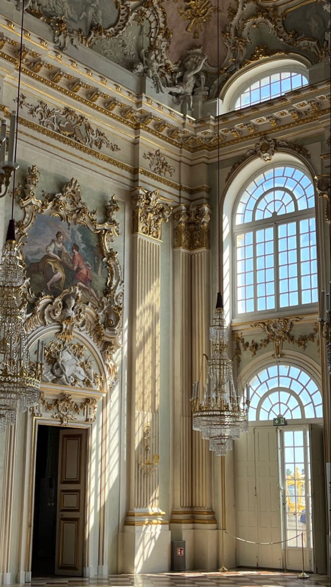 an ornately decorated room with chandeliers and paintings on the walls, along with large windows