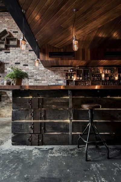 a bar with two stools in front of it and brick walls on the side