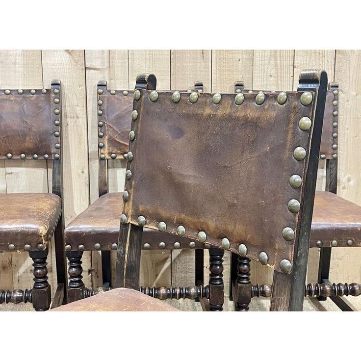 three brown leather chairs with metal studs on them