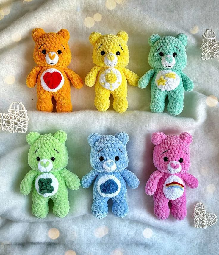 four crocheted teddy bears sitting on top of a bed next to each other