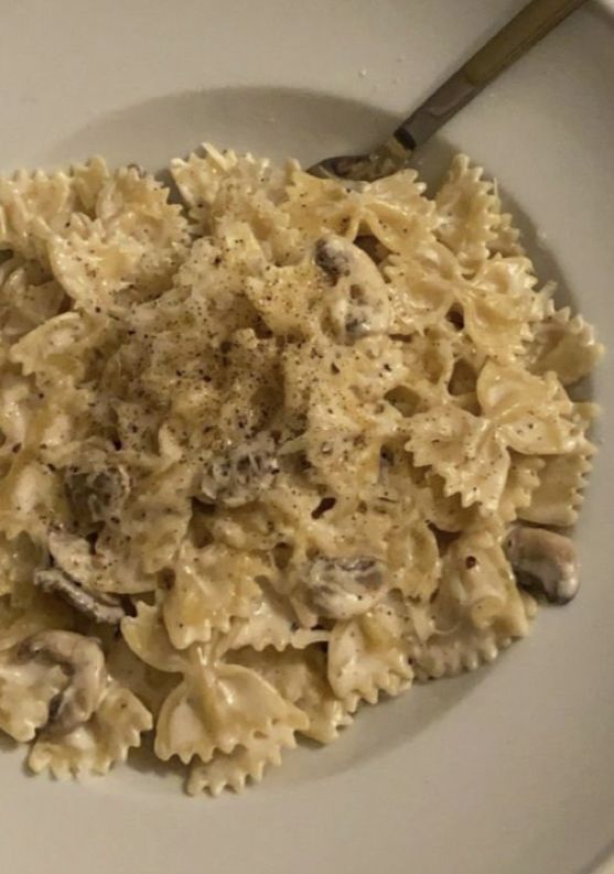 a white plate topped with pasta and mushrooms