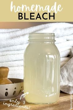 a jar filled with liquid sitting on top of a wooden table next to white towels