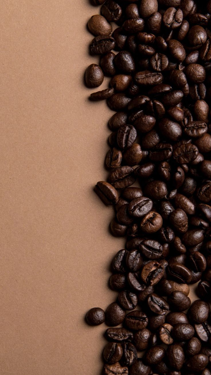 coffee beans scattered on top of each other in front of a brown background with a white border