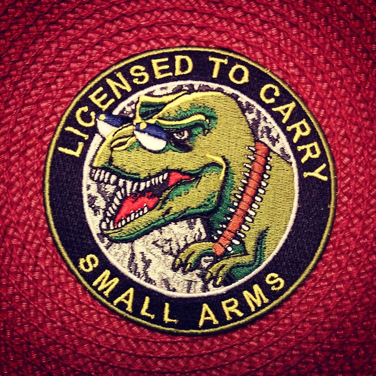 a red jacket with the words license to carry and an image of a dinosaur on it