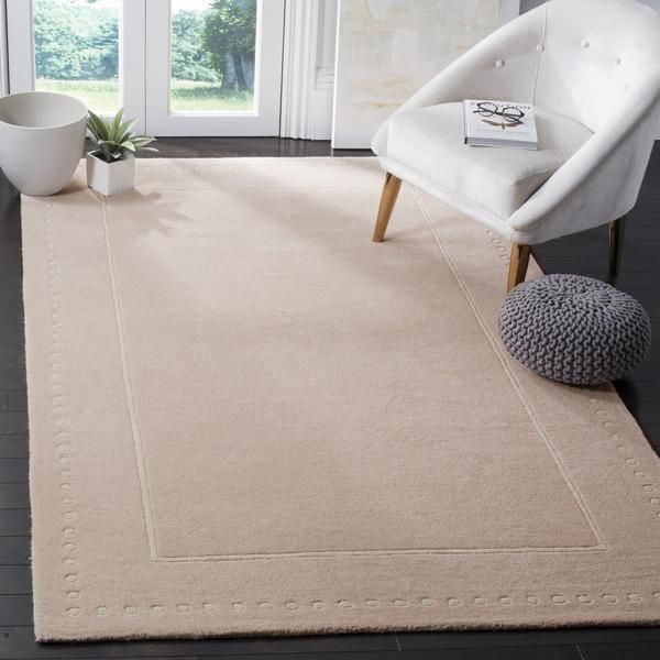 a living room with a white chair and rug on the floor next to a window