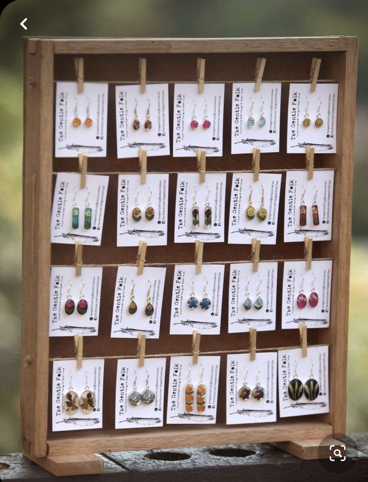 a wooden display with earrings on clothes pins