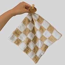 a hand holding a white and gold checkered towel