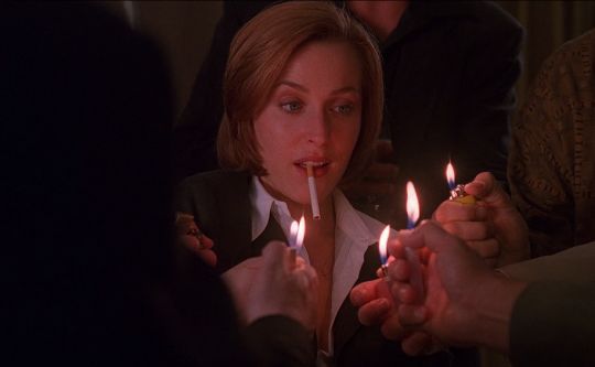 a woman lighting candles in her mouth while others look on