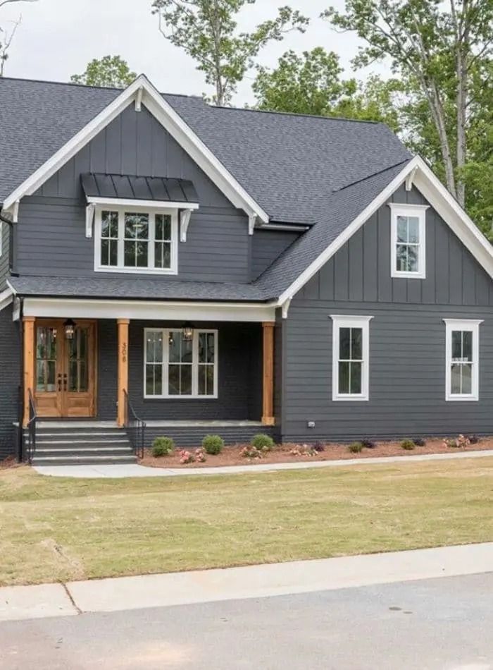 a gray house with white trim and two story windows on the second floor is shown