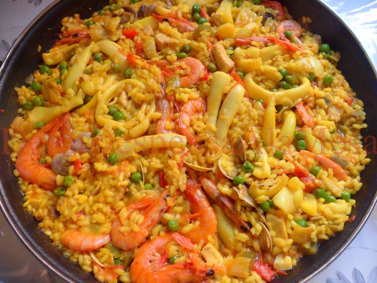 a pan filled with rice and vegetables on top of a table