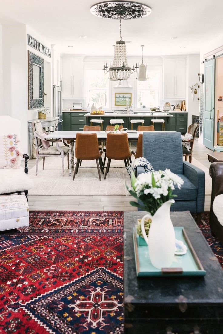 a living room filled with furniture and a rug on the floor in front of a table