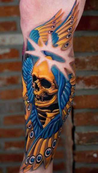 a man's leg with a skull and wings on it