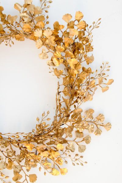 a wreath made out of gold leaves on a white background