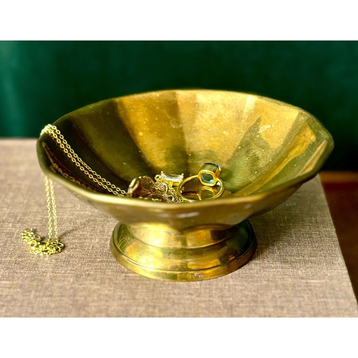 a gold bowl with a chain in the middle