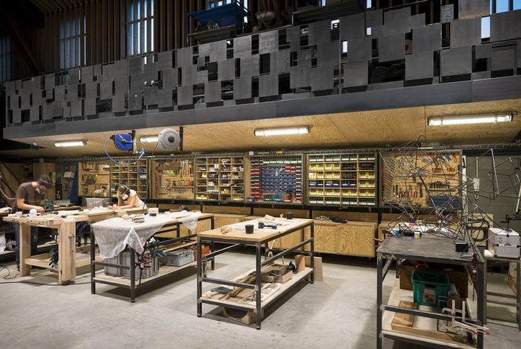 a woman working in a woodworking shop with lots of work on the tables and shelves