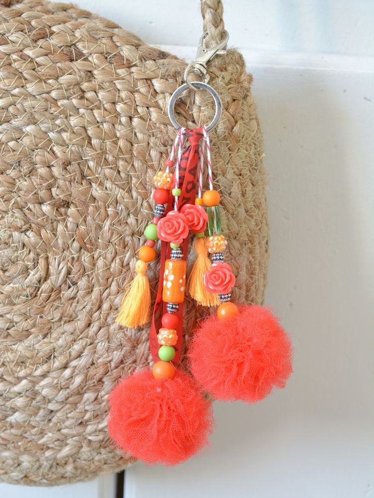 an orange tasseled keychain hanging from a wall