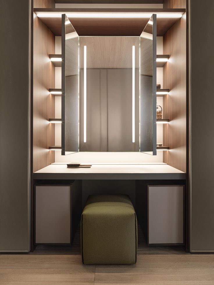 an empty dressing room with a stool and mirror on the wall, along with shelves