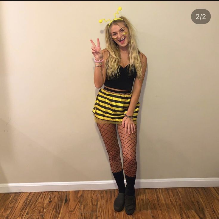 a woman posing for the camera with her hand up in front of her face and wearing fishnet tights