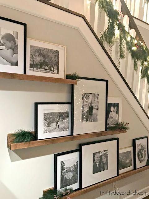 the stairs are decorated for christmas with pictures on them and garland hanging from the banister