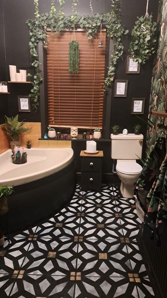 a black and white tiled bathroom with plants on the wall