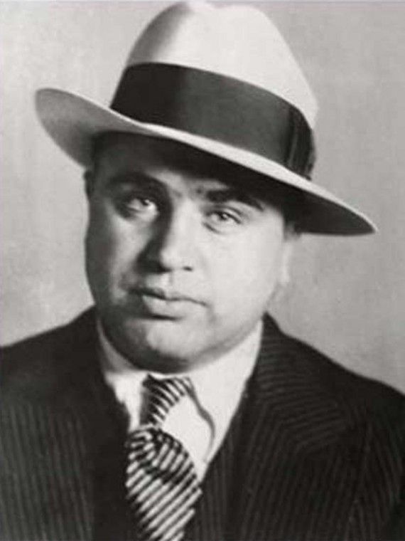 a black and white photo of a man wearing a hat with the caption al capone