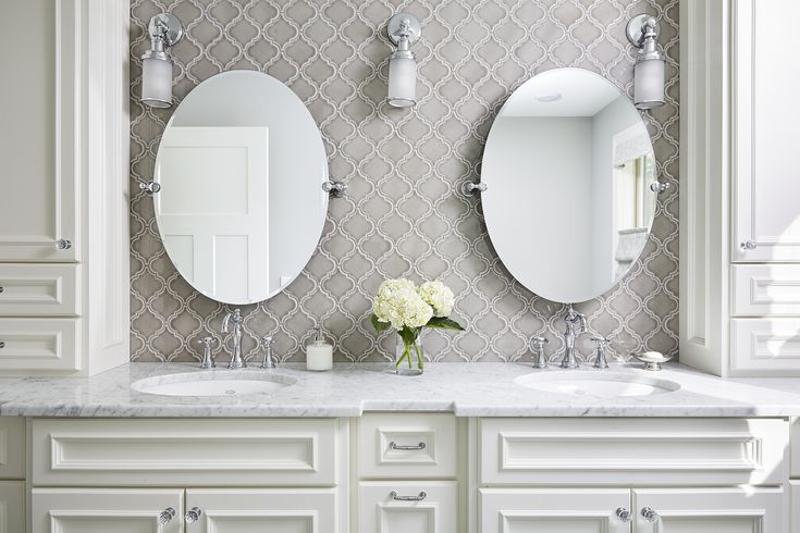 there are two sinks in the bathroom with mirrors on the wall above them and one is white