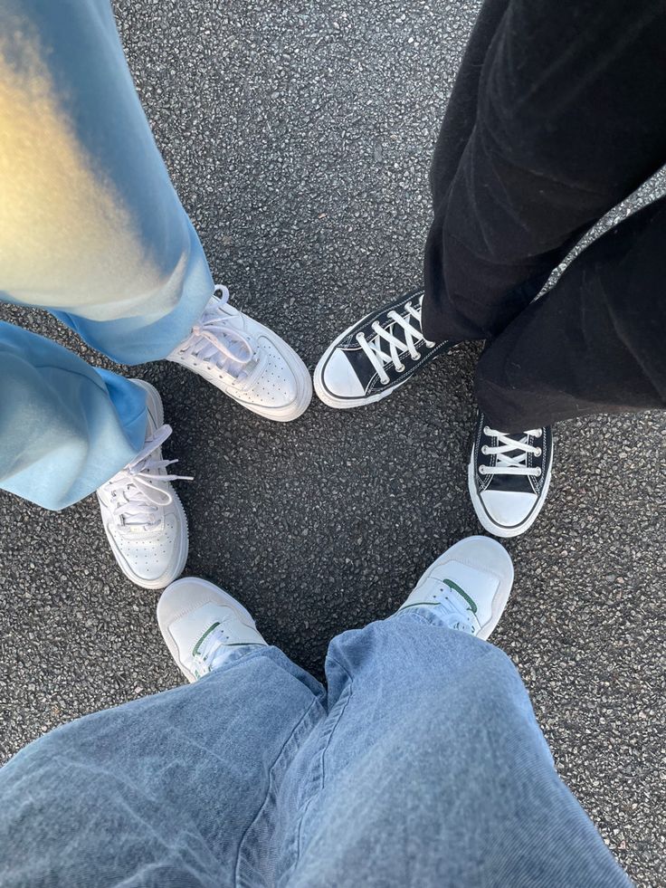 three people standing in a circle with their legs crossed