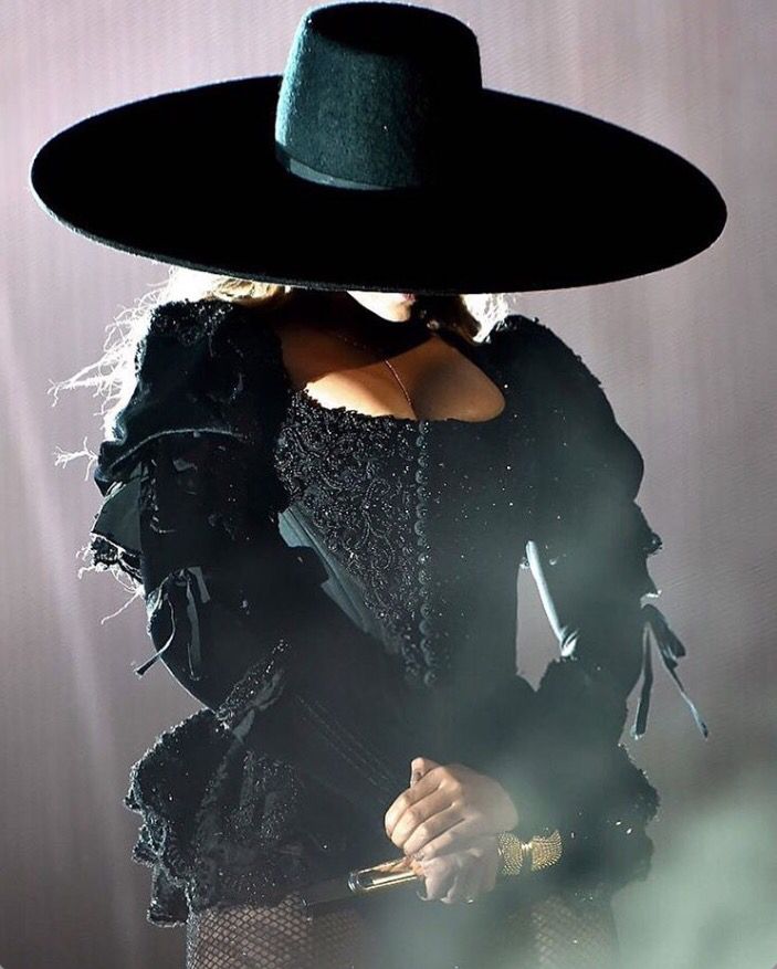 lady in black outfit and hat on stage