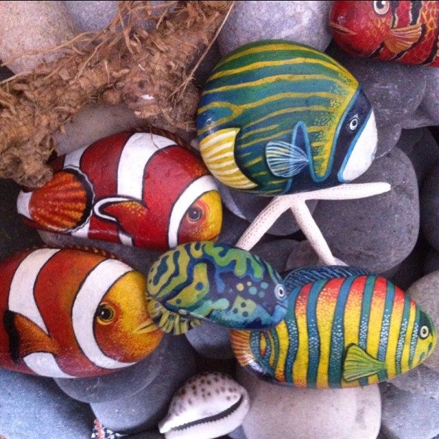 several colorful fish painted on rocks and pebbles