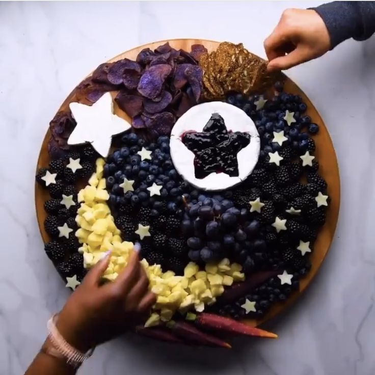 someone is decorating a plate with stars and berries for the fourth of july holiday