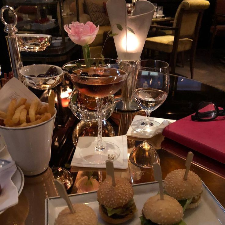 a table topped with sandwiches and glasses of wine