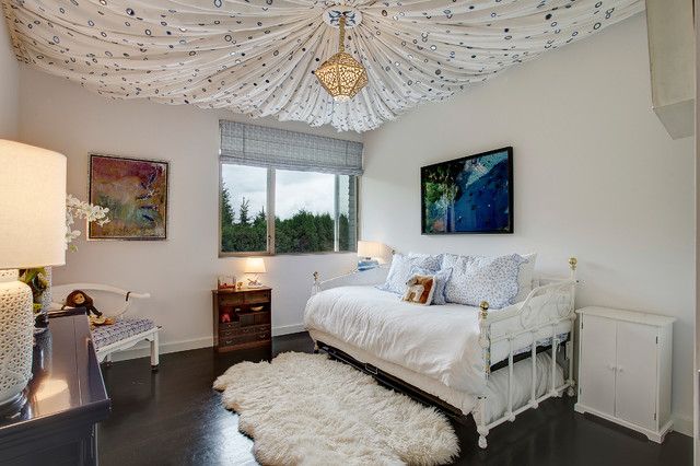 a bedroom with a white bed and chandelier hanging from the ceiling above it