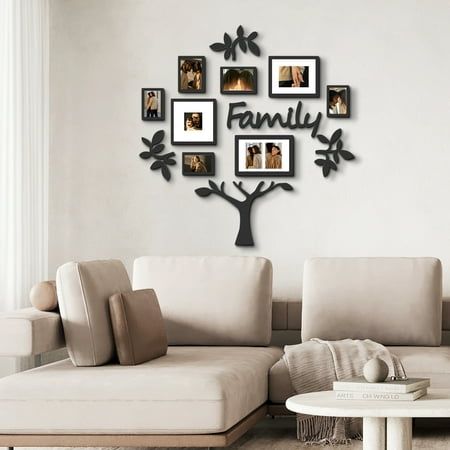 a living room with a couch, coffee table and family tree wall hanging on the wall