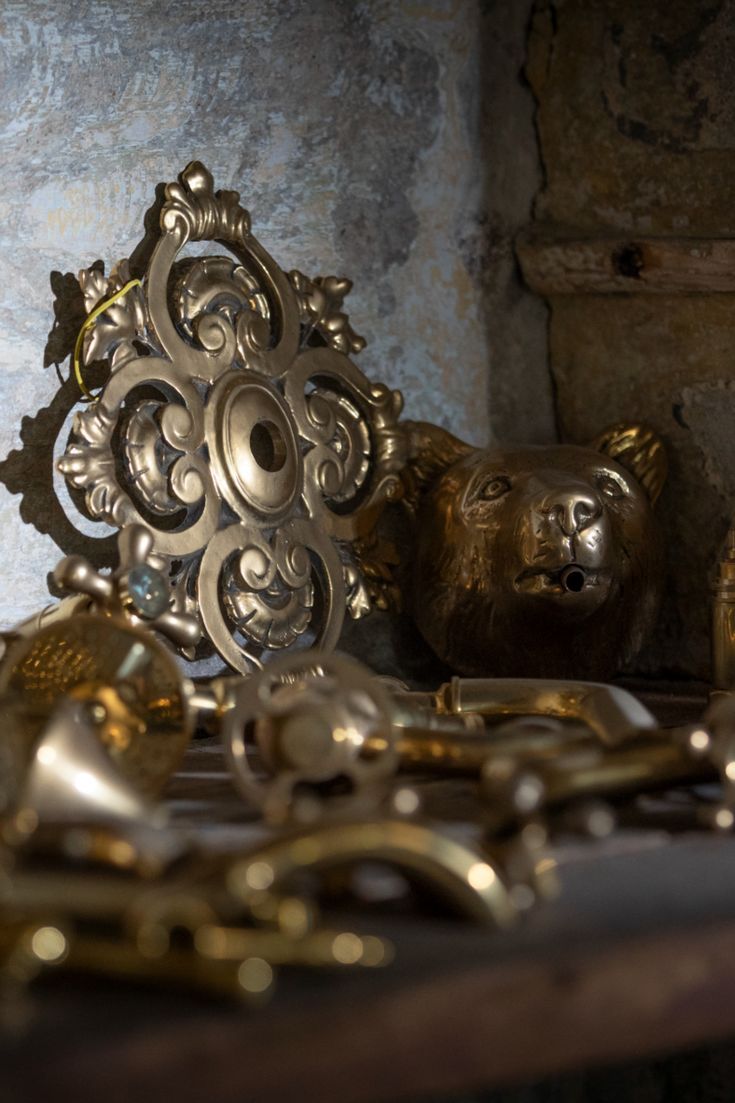 there are many brass items on the table and one has a bear head in it