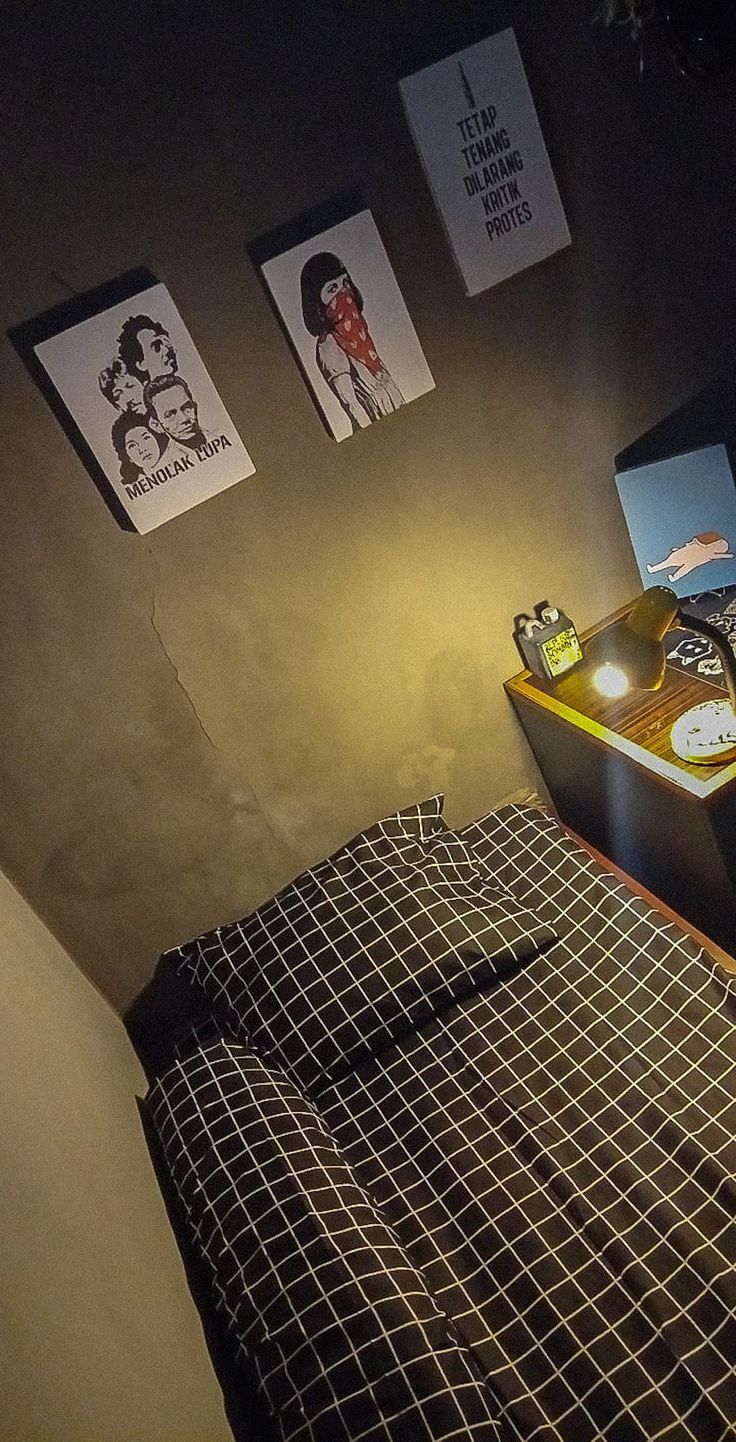 a bed in a room with pictures on the wall