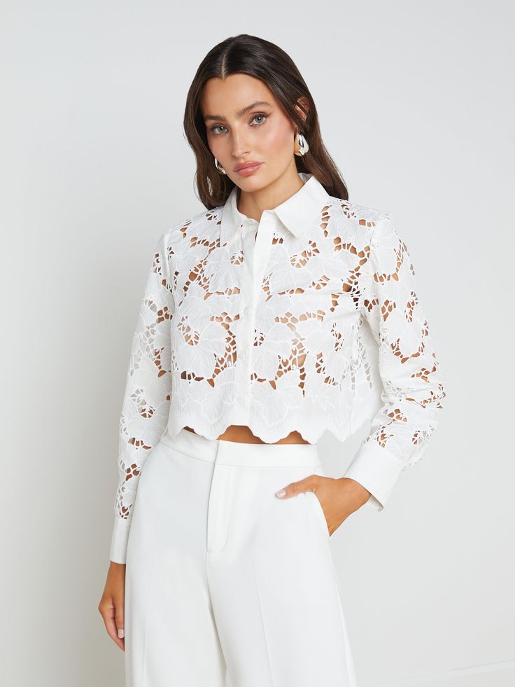 The Seychelle is our fresh, modern take on the lace blouse. A boxy, cropped fit delivers a cool, effortless feel that balances the feminine floral lace. A sharp collar and button-cuff sleeves add a tailored crispness. Throw the Seychelles on over your swimsuit for sophisticated beach style, or pair it with our Livvy pant for a beautiful monochromatic look. | L'AGENCE Seychelle Lace Cropped Blouse Top In White Lace Shirt Outfit, Lace Blouses, White Lace Shirt, Image Consulting, Cutout Blouse, Rodeo Outfits, Bridal Separates, Cropped Blouse, 50 Style